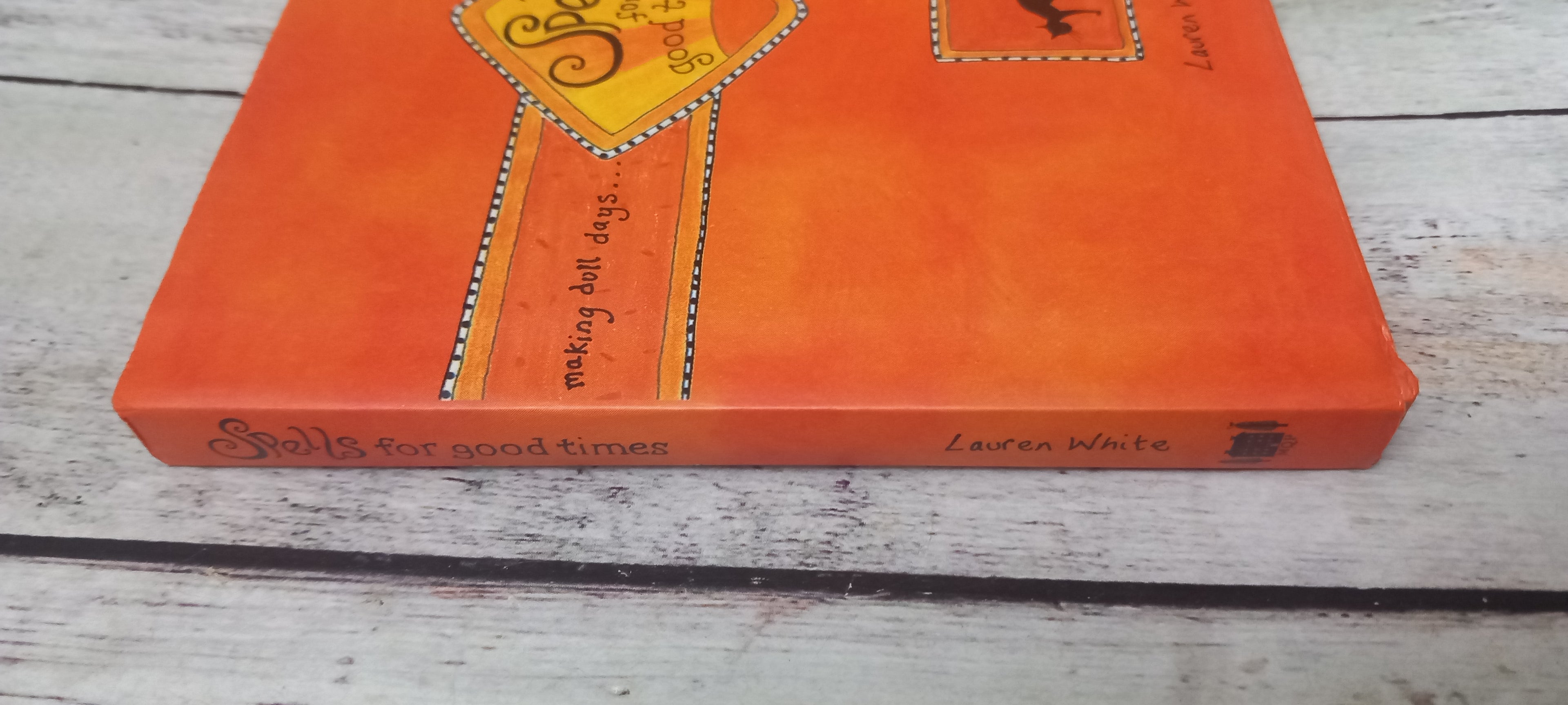 An orange hardcover book titled 'Soul for good times' by Lauren White, resting on a light-colored wooden surface.